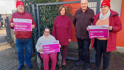 Männer und Frauen mit Plakaten in der Hand.