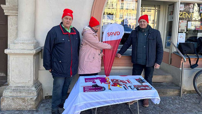 Zwei Männer und eine Frau hinter einem Tisch mit SoVD-Material