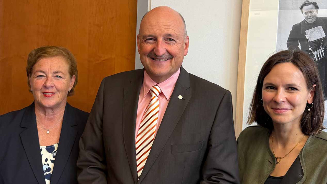 Drei Personen stehen vor einer Büro-Wand im Bundestag. Es sind der Abgeordnete und Ausschussvorsitzende Bernd Rützel mit Michaela Engelmeier und Henriette Wunderlich vom SoVD.