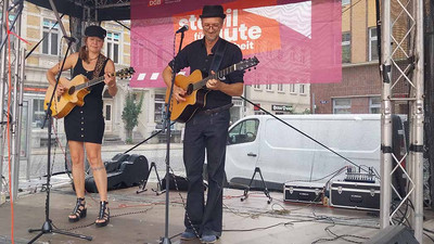 Frau und Mann auf Bühne mit Gitarren.