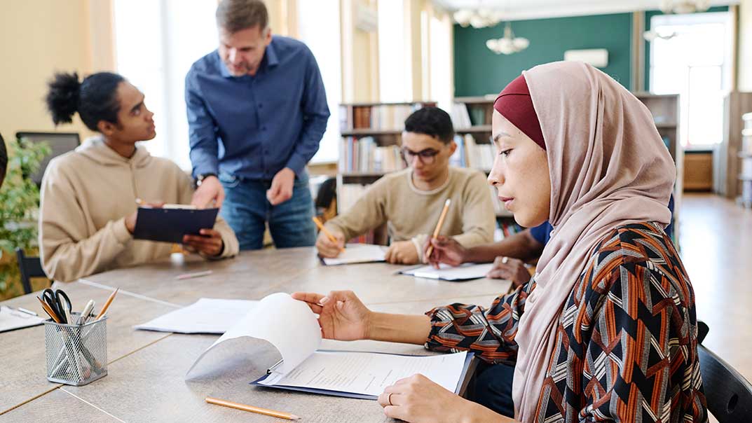 Migrationen und Migranten mit einem Lehrer in einem Unterrichtsraum. 