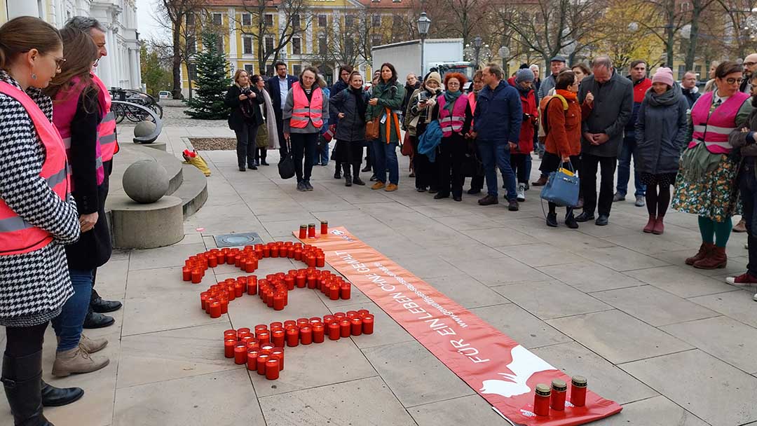 Viele Menschen stehen vor 133 Kerzen auf der Straße