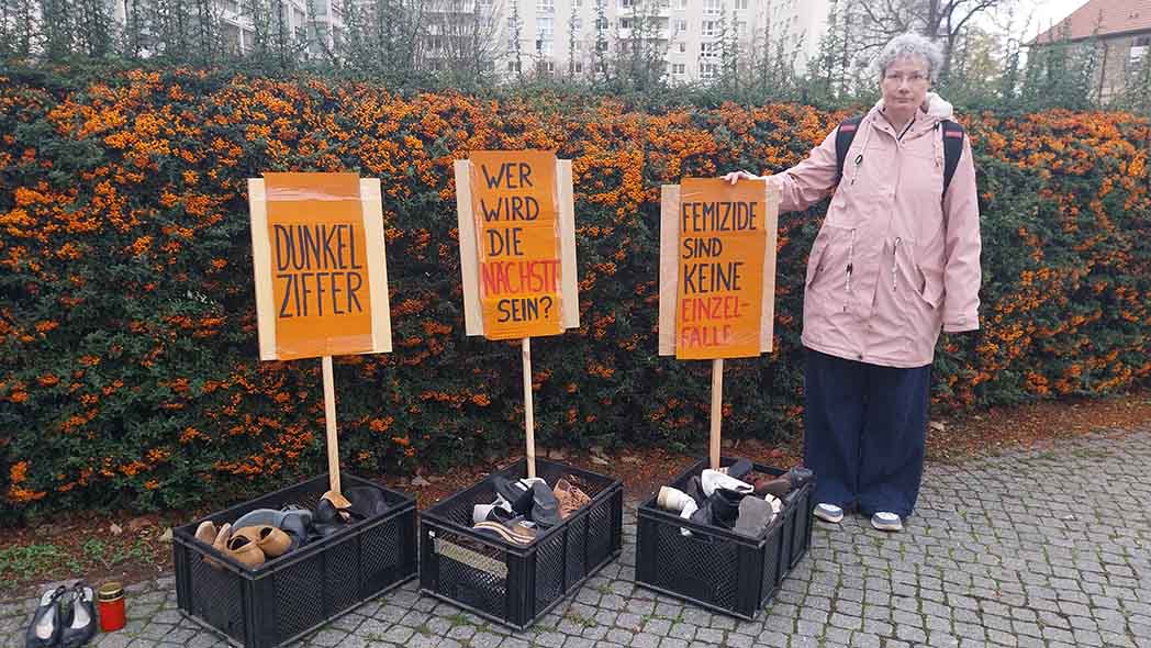 Drei Schilder mit Kästen in Schuhen und Frau daneben.