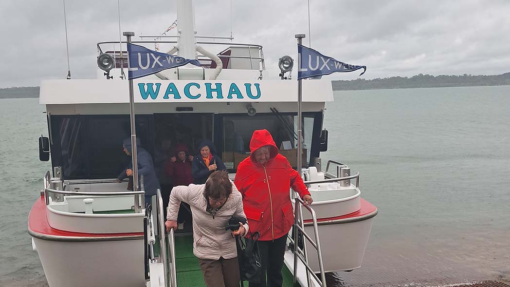 Zwei Frauen gehen vom Schiff aufs Land.