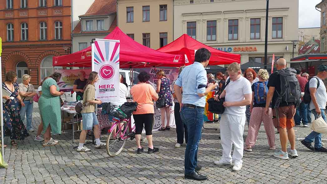Platz mit Menschen und Infoständen.
