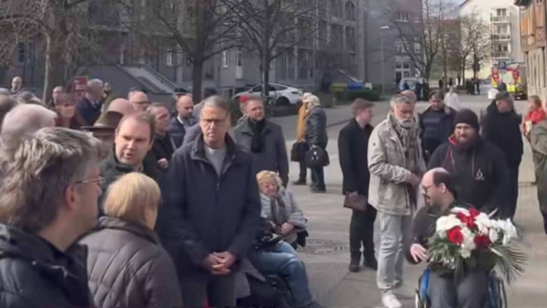 Dr. Karsten Lippmann legte Blumen ab, Kerstin Römer ist im Hintergrund zu sehen.